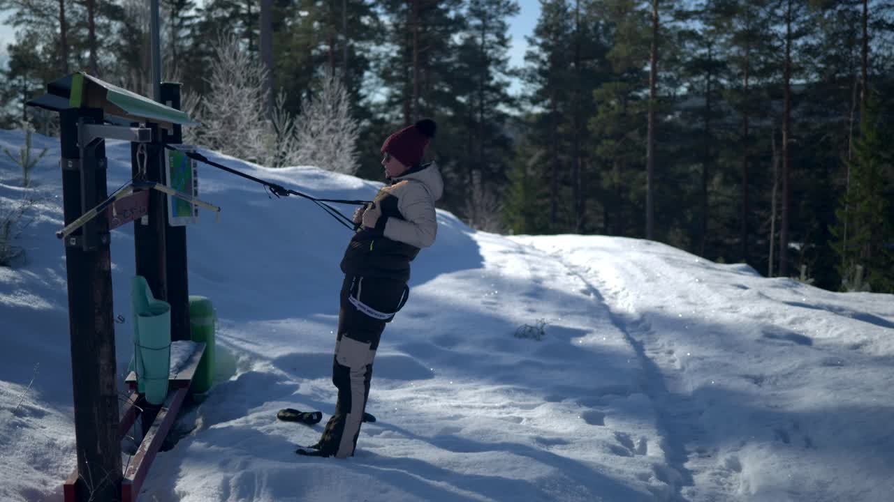 A Female Doing Training at Outdoor Gym during Winter with Snow and Forest Background