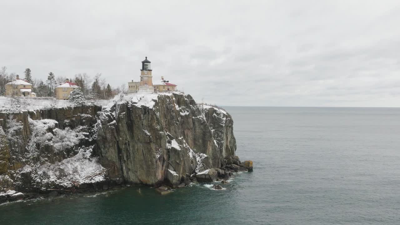 Split Rock Lighthouse On Icy Cliff And Snowy Shore Of Lake Superior In Two Harbors, Minnesota. drone approach