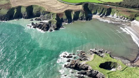 ireland coast the sheltered kilmurrin cove sea caves and blowholes copper coast waterford static drone shor