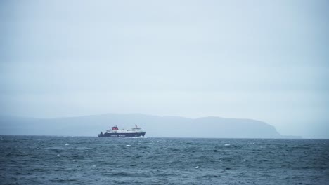 ferry sailing on the ocean towards the mountains