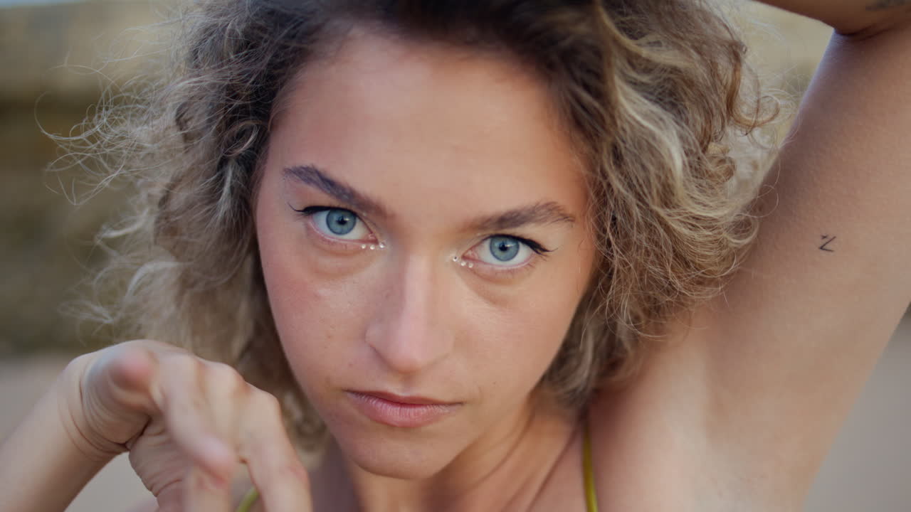 bailarina en primer plano moviendo las manos suavemente en la playa de arena.