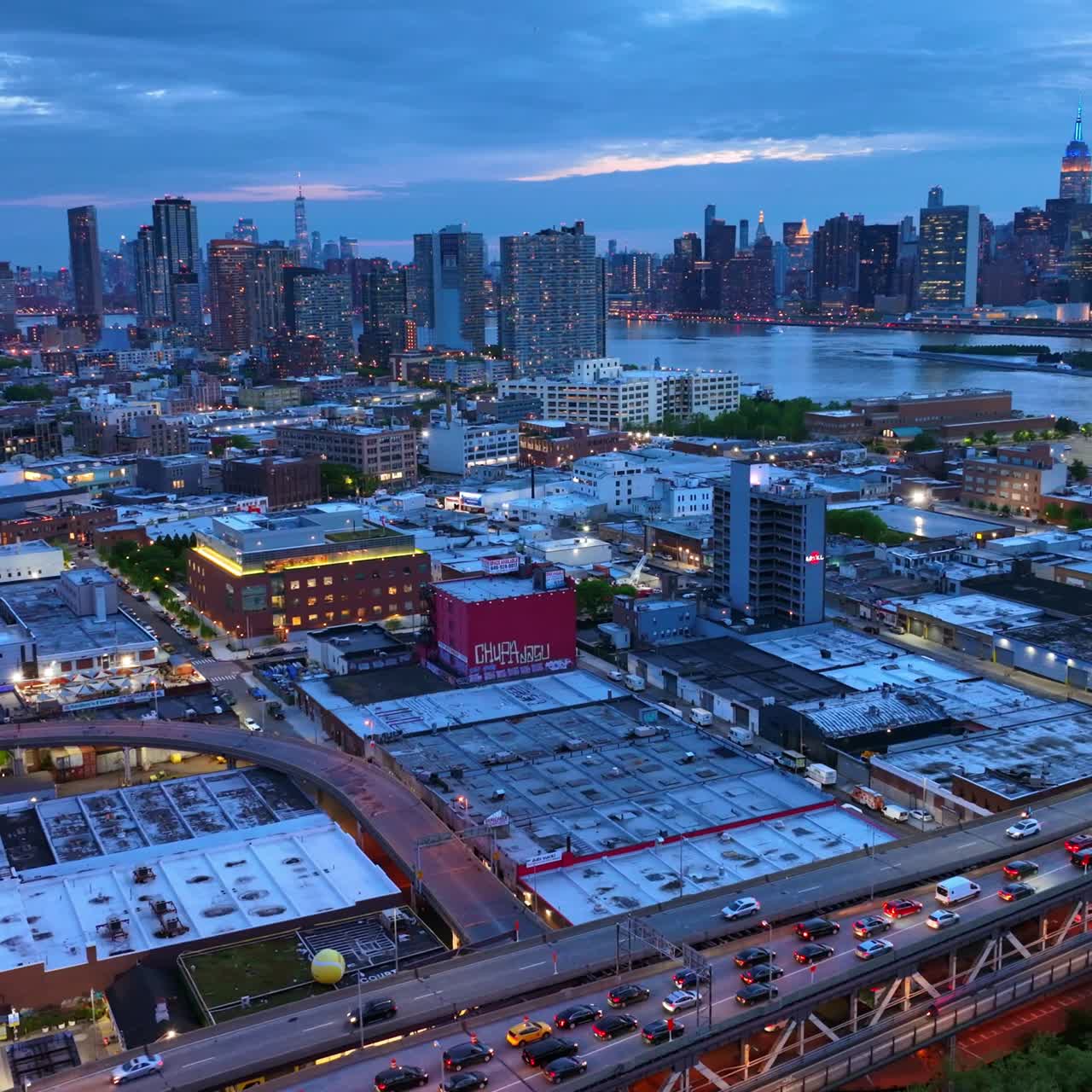 Magnificent city view in Long Island. Numerous cars in traffic jams. Skyscrapers with lights at backdrop
