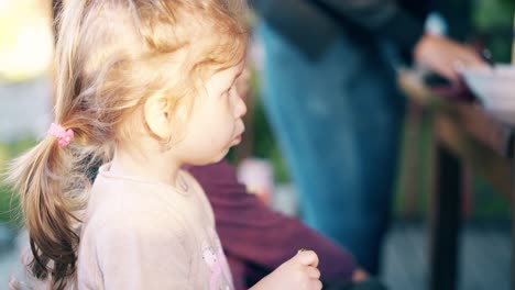 close-up mamá alimenta porridges de los niños que se sientan en una casa de verano