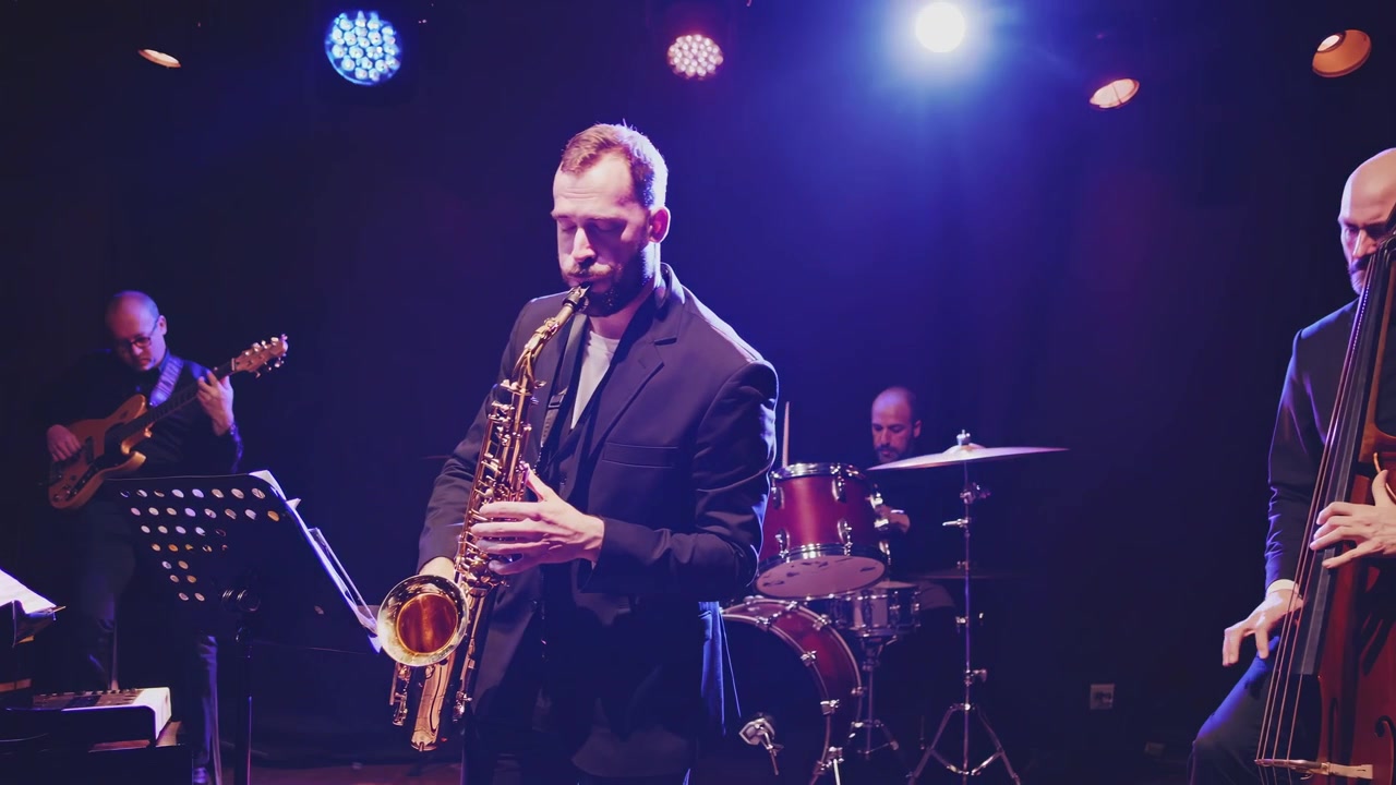 Gruppo jazz che si esibisce dal vivo sul palco con sassofono, basso e batteria