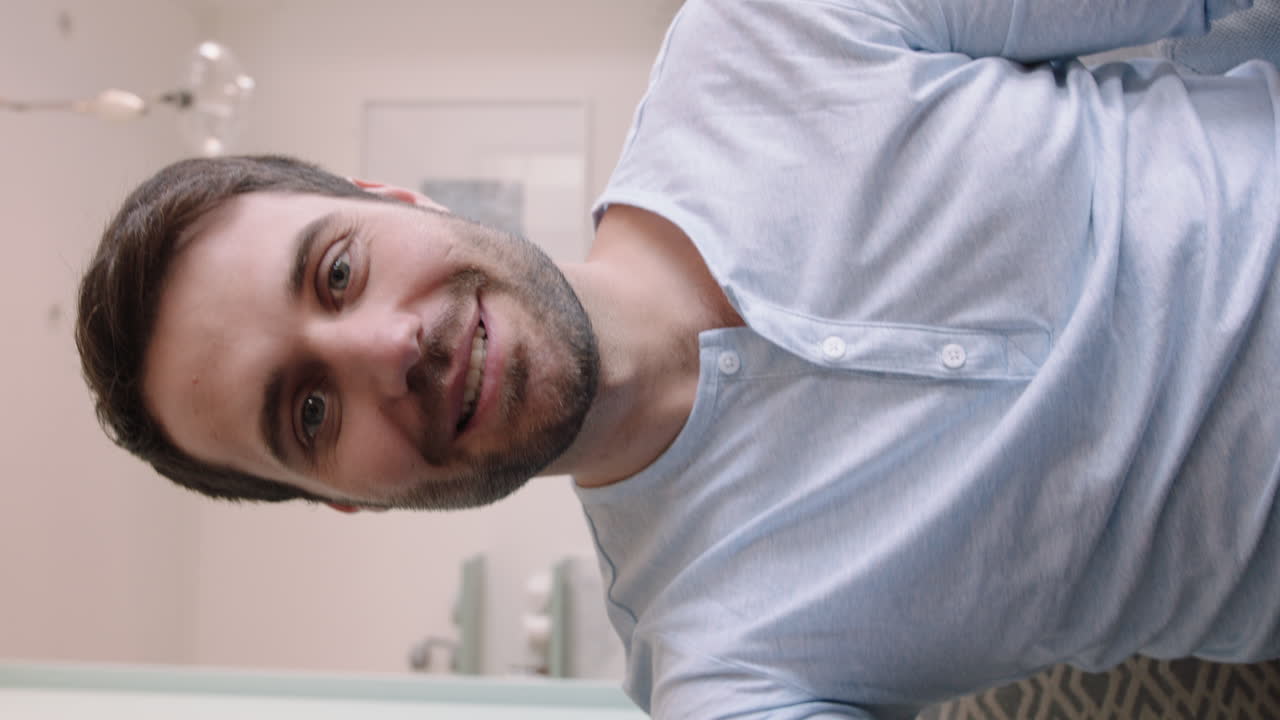 hombre caucásico atractivo teniendo video chat usando cámara web en casa mostrando su apartamento charlando compartiendo estilo de vida disfrutando de la comunicación en línea en pantalla vertical