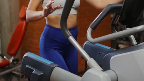 donna che lavora su un tapis roulant in palestra