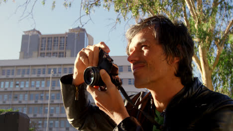 male photographer taking photos in city street 4k