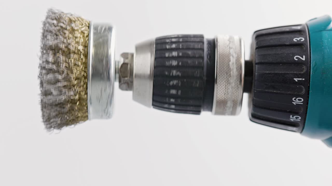 색 배경에 회전하는 둥근 강철 질을 가진 손 드릴