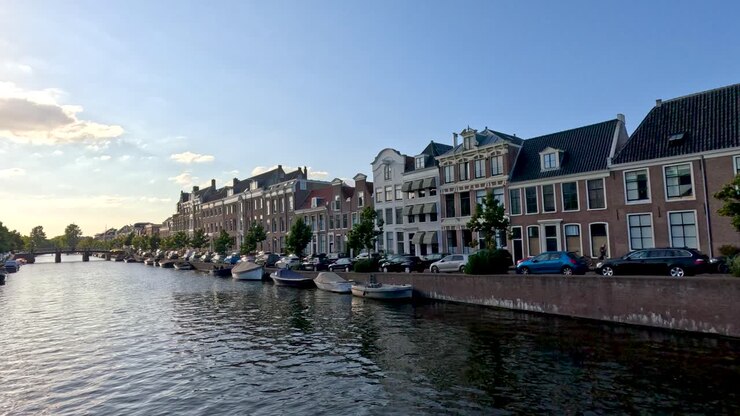 La telecamera scorre lungo il canale di Haarlem, catturando l'architettura sul lungomare, le barche, i riflessi e la delicata illuminazione del tramonto