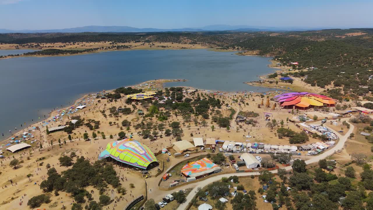 Drone flyover captures full Boom Festival grounds by Lake Idanha, Idanha-a-Nova, Portugal