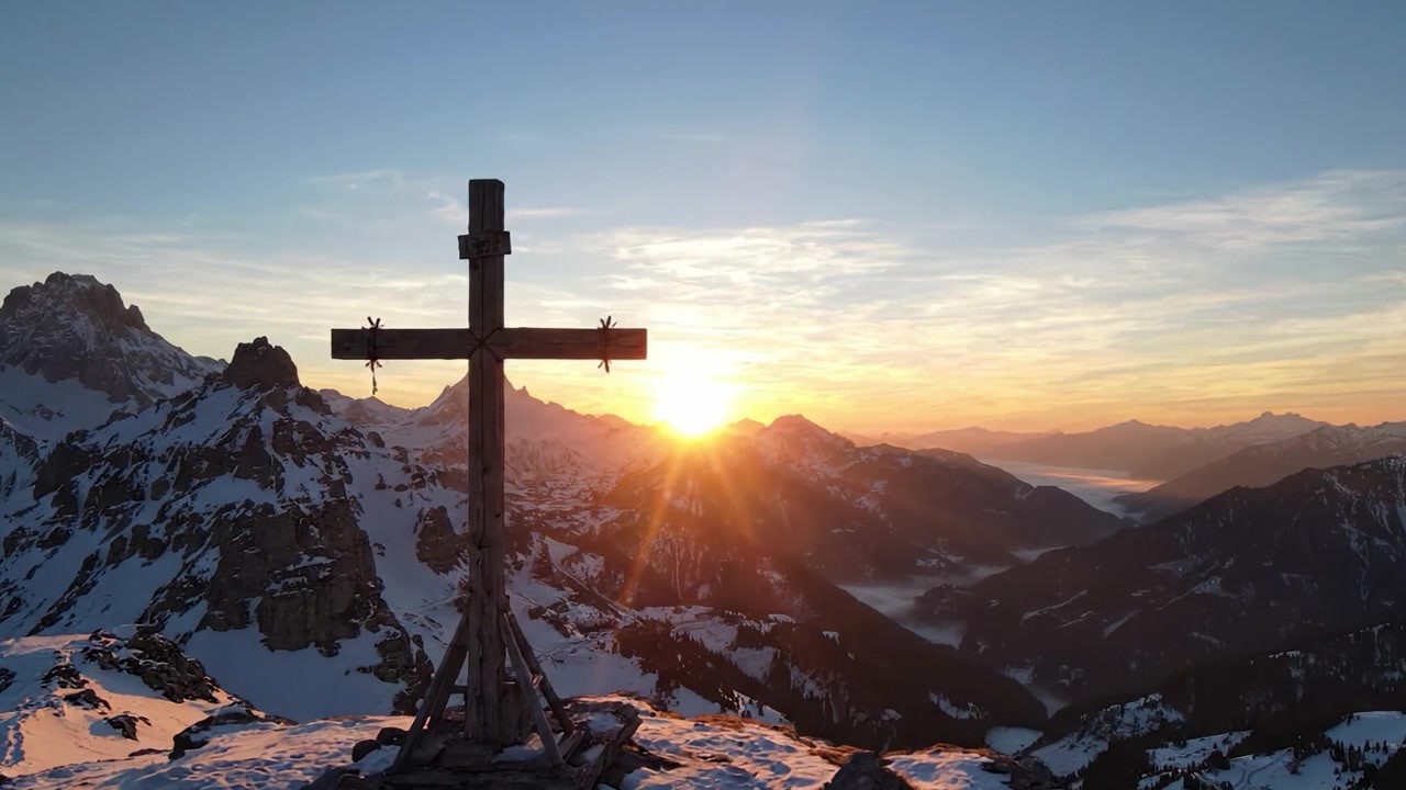 Ein majestätischer Sonnenaufgang über schneebedeckten Bergen mit einer Kreuzsilhouette, der die Schönheit der Natur und die Ruhe im frühen Morgenlicht einfängt.