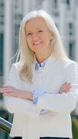 Portrait of a professional woman with white hair and arms crossed