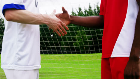 dos jugadores de fútbol estrechando la mano