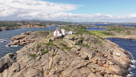 stavernsodden lighthouse stands tall on top of rocky coastal on a cloudy day in stavern, norway