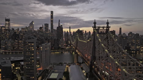 v354 aéreo de nueva york sobre el east river y la isla roosevelt a lo largo del puente de queensboro hacia el centro de la ciudad, capturando el brillante paisaje urbano de manhattan al anochecer - filmado con mavic 3 pro cine - septiembre 2023