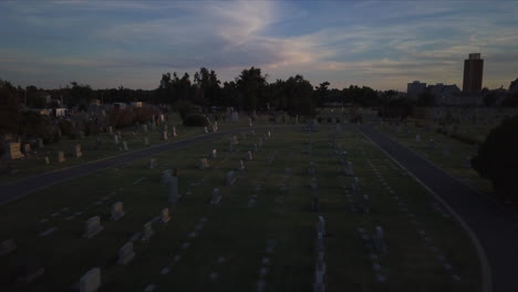 backward dolly above a cemetery at dusk with fading light