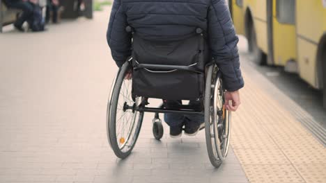 person with a physical disability waiting for city transport with an accessible ramp