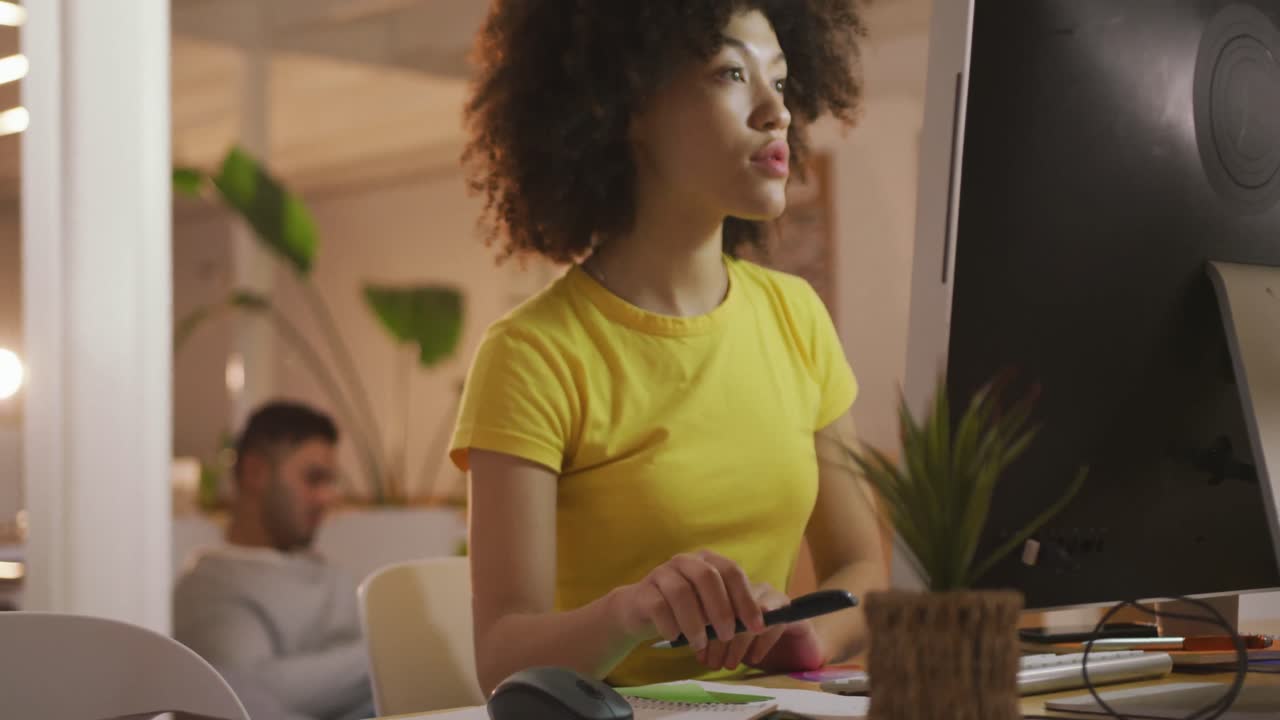 mujer de raza mixta trabajando en una oficina creativa