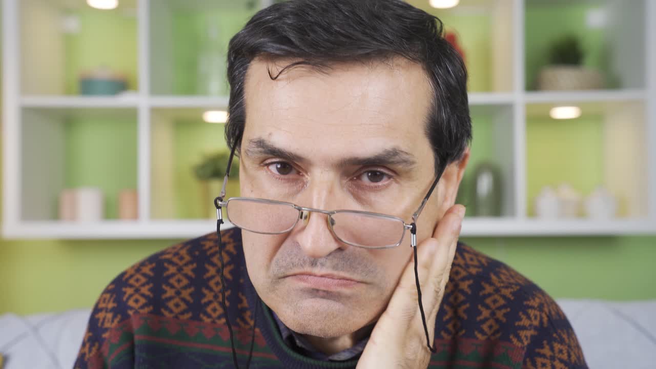 un anciano enojado y gruñón enojándose en casa.