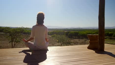 Woman-meditating-yoga-on-wooden-plank-4k