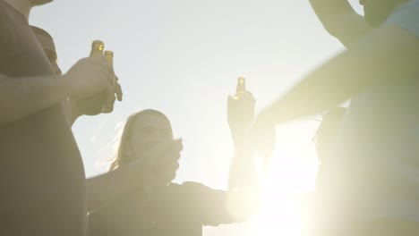 Smiling-people-clinking-beer-bottles-during-party