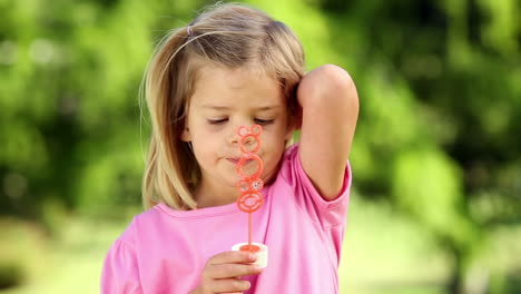 little girl playing with bubbles in the park