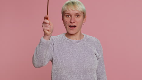 woman with a magic wand smiling at the camera