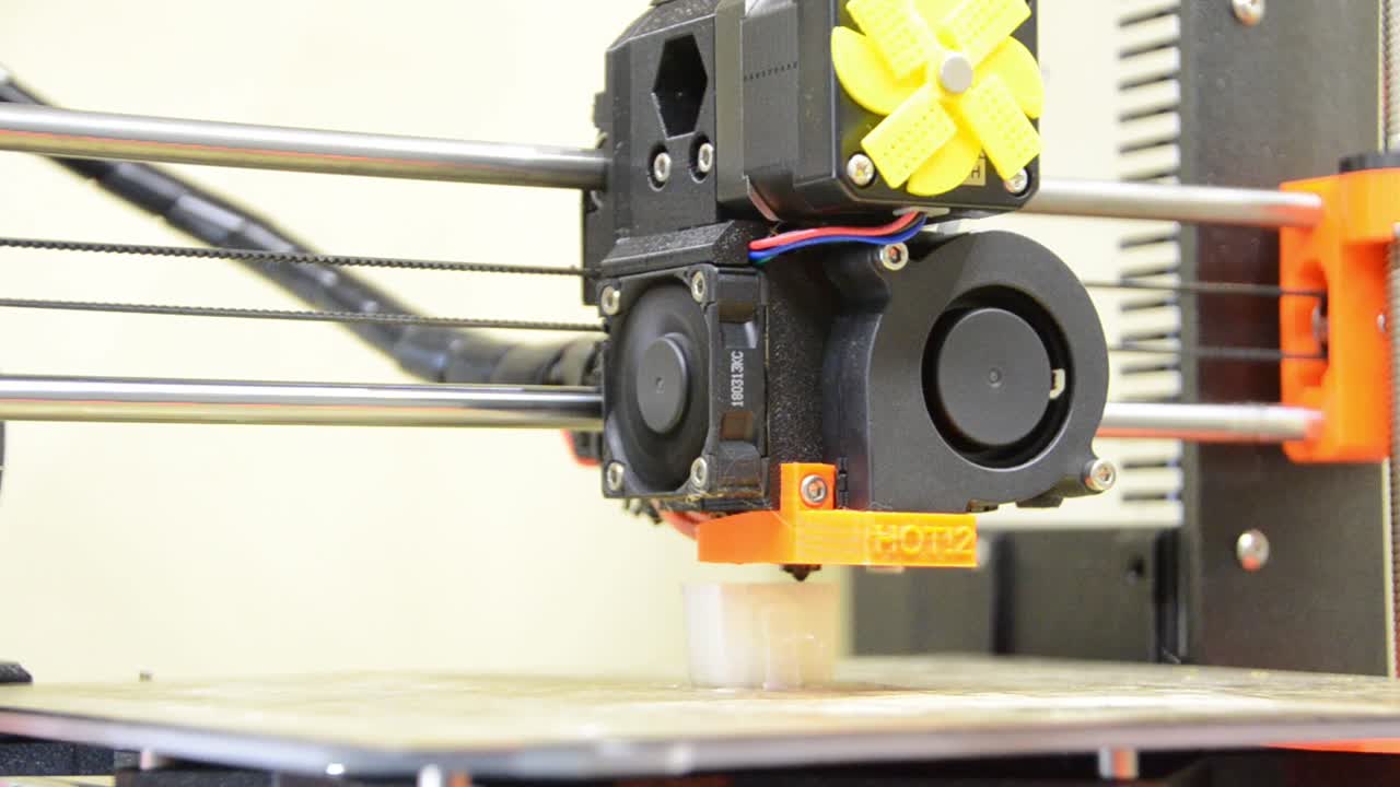 3D printer printing an items that shows the print bed and head moving