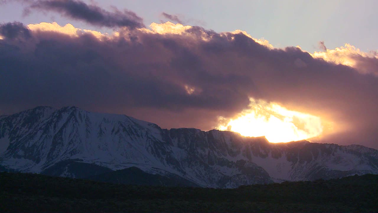 구름 사이로 태양이 빛나는 눈 덮인 시에라 네바다 산맥의 시간 경과
