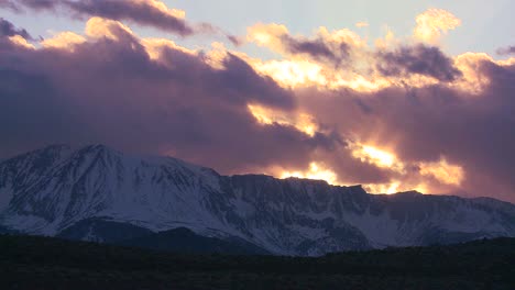 time lapse of the snowcapped sierra nevada mountains with the sun shining through clouds