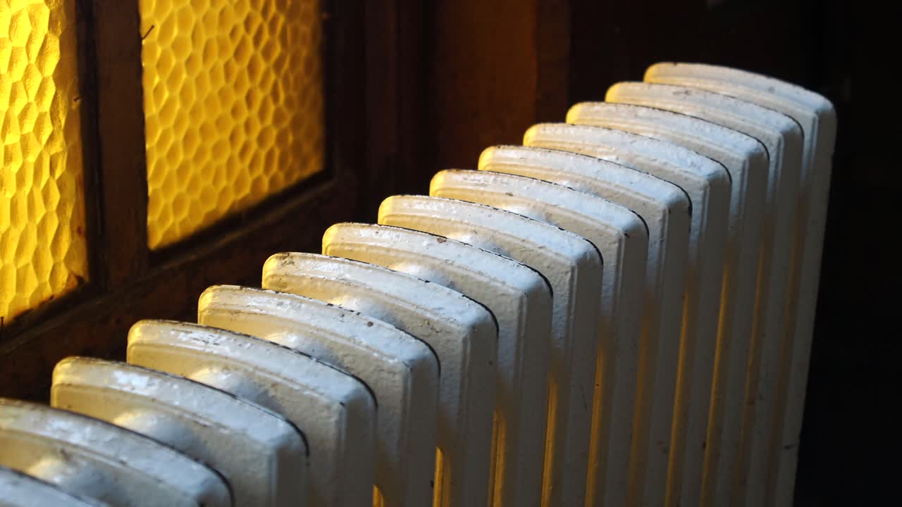 близкий взгляд на старый белый чугунный радиатор