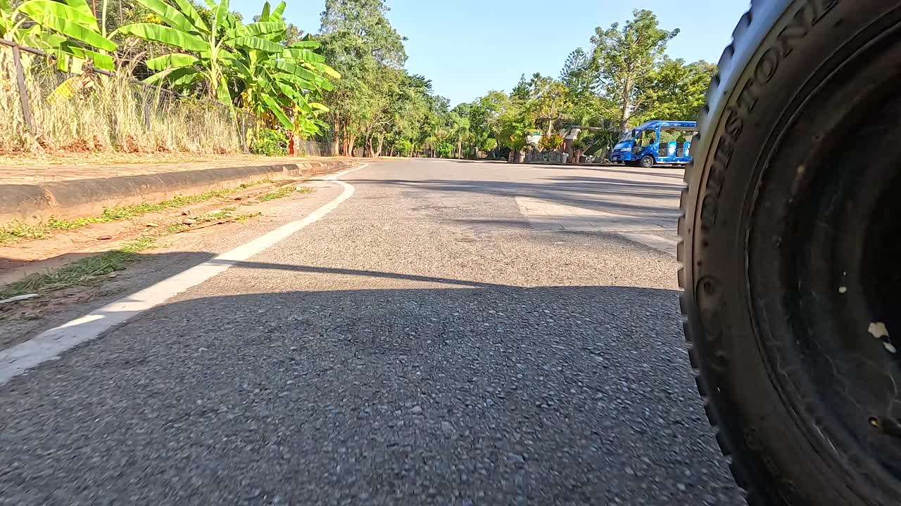 una rueda se mueve a lo largo de una carretera de parque soleado