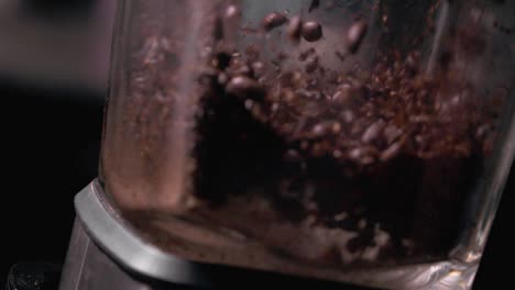 super slow motion of coffee beans being ground in a high-speed blender