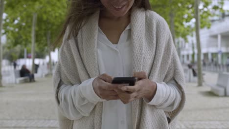 smiling mature woman holding smartphone