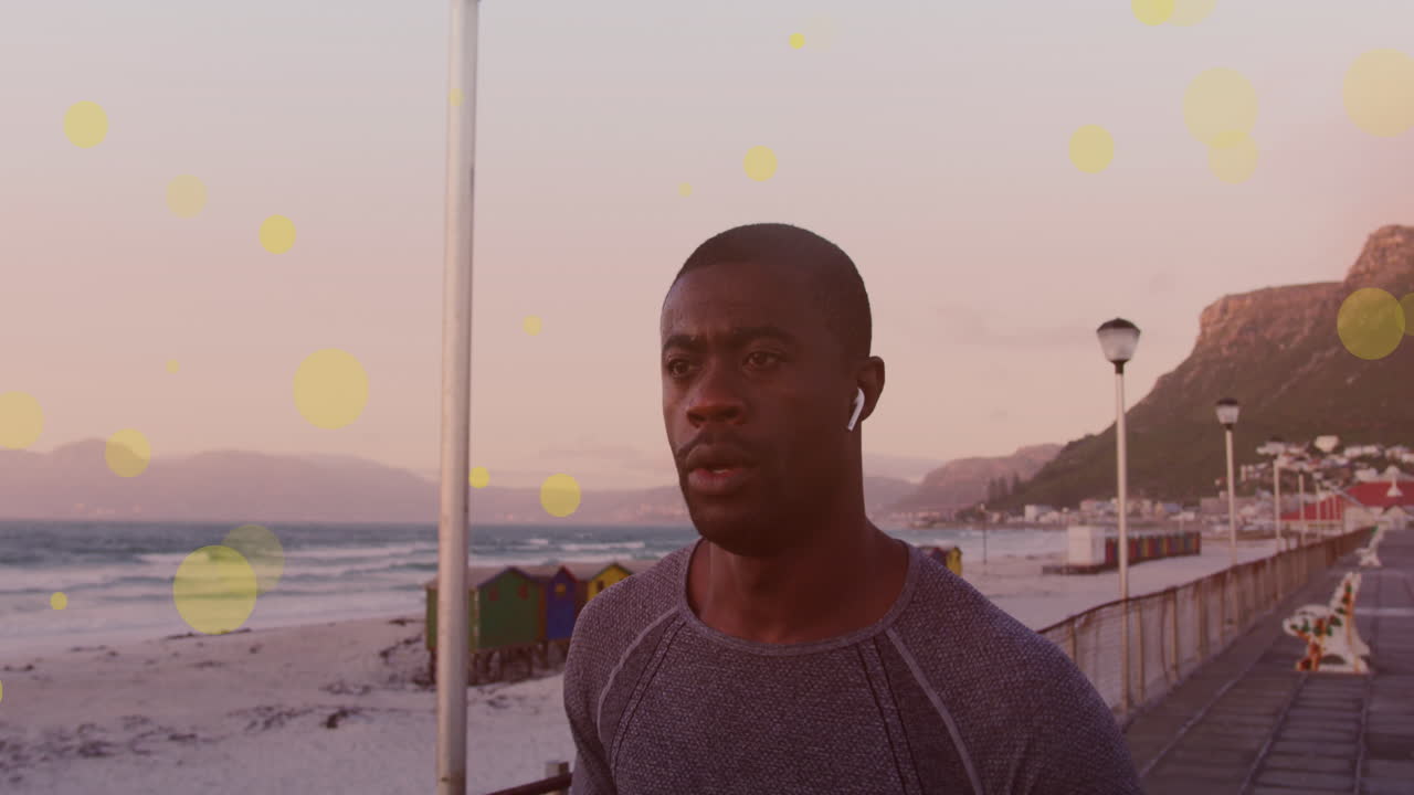 아프리카계 미국인 피트 남자가 산책로에서 달리는 노란색 반점이 떠다니고 있습니다.