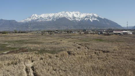 drone shot of powell slough wetland area with snow capped mountains on horizon