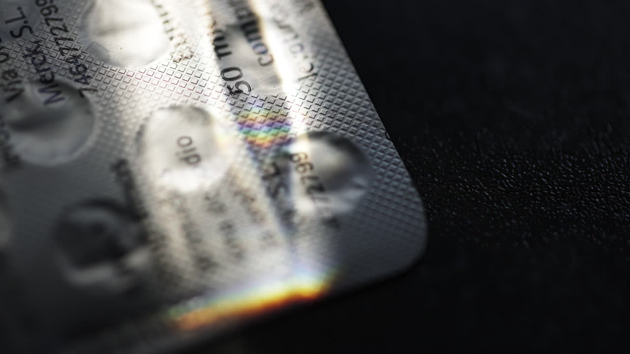 Close-up of Blister Pack with Pills and Rainbow Light Reflection