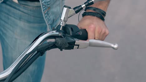 hombre de primer plano se sienta en una motocicleta sosteniendo el manillar negro