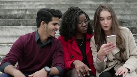 Young-people-outside,-girl-with-phone-googling-place-to-go