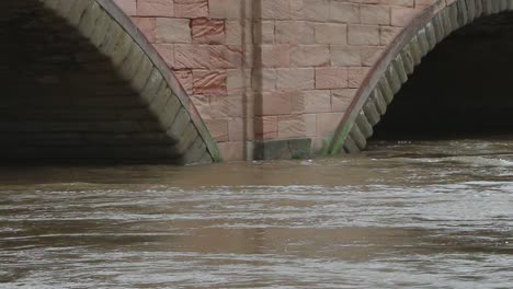 the river severn in flood, flowing around the bridge at bewdley