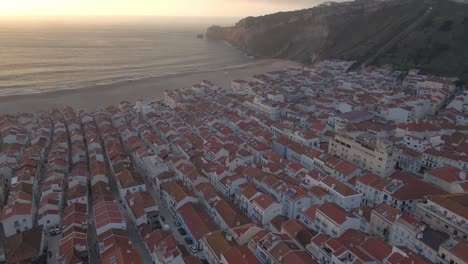 Flächendrohnenaufnahmen-Der-Stadt-Nazare-An-Der-Küste-Portugals,-Gefilmt-Während-Der-Goldenen-Stunde-Des-Sonnenuntergangs-4k