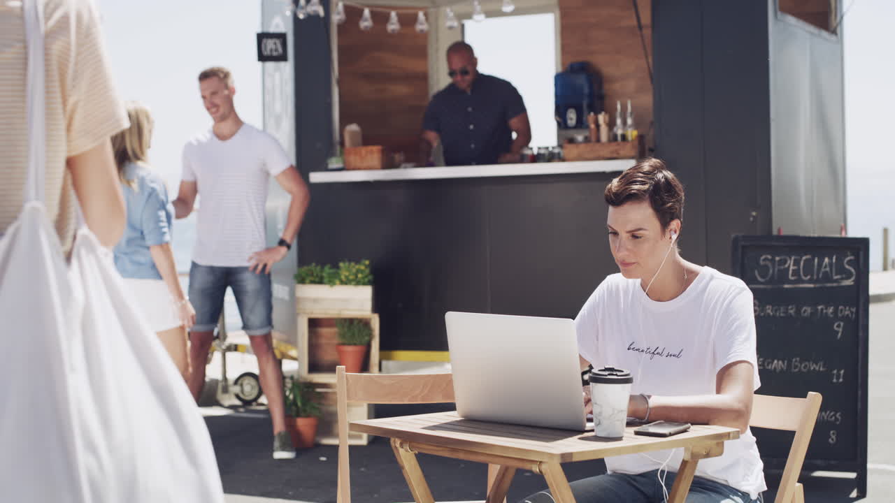 una mujer joven usando una computadora portátil frente a su comida