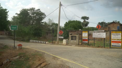 Pradhan-Mantri-Gram-Sadak-Yojana-signage-at-the-entrance-of-a-village,-Bihar,-India,-Wide-angle-shot