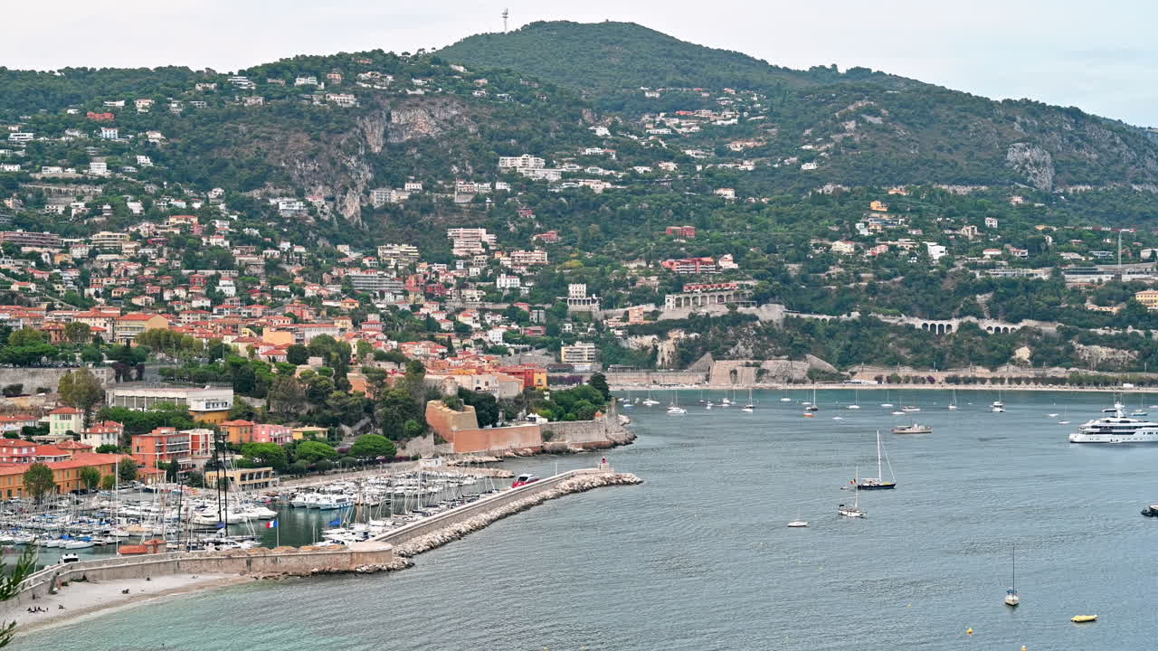Vista della costa del Mar Mediterraneo a Saint-Jean-Cap-Ferrat, colline con vegetazione, edifici residenziali, yacht, Francia