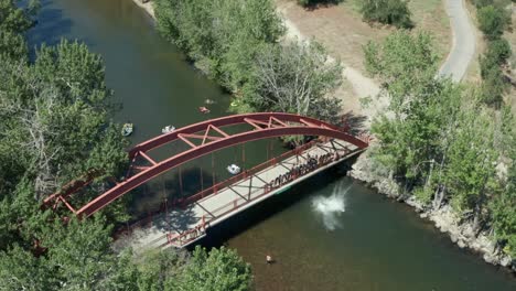 Imágenes-De-Drones-A-60-Fps-De-Personas-Saltando-De-Un-Puente-Rojo-Hacia-El-Río-Boise