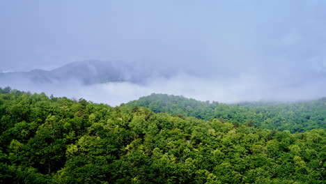 Aerial approach into mist resting across Appalachian ridges