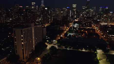 chicago skyline revealed at night as drone flies between skyscrapers