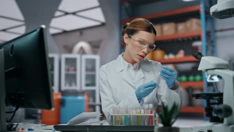 experto de laboratorio comprobando tubos de ensayo tomando notas en la clínica de cerca. mujer científica