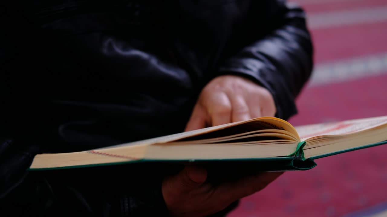 leyendo el libro sagrado musulmán el corán en una mezquita
