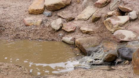 water flows over rocks into a small pool